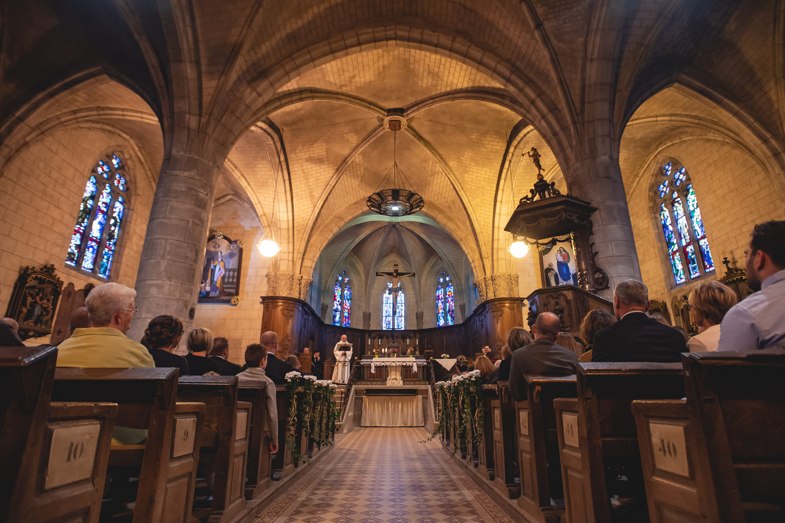 Intérieur d'une église avec fidèles et autel.