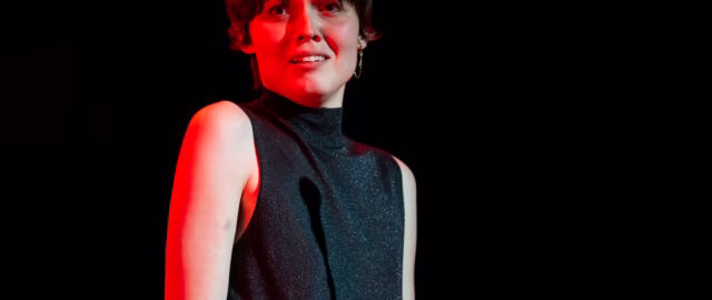 Personne en lumière rouge sur fond noir.