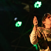 Portrait de Biga*Ranx en concert, mettant en avant son style unique mêlant dub et reggae, avec une ambiance lumineuse immersive.