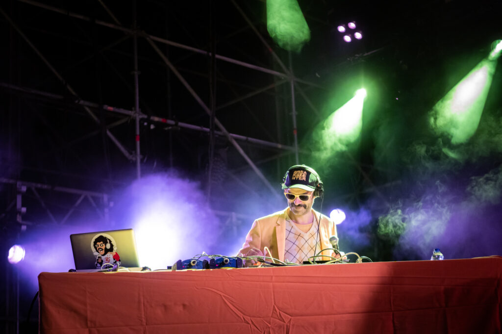 Photographie dynamique du groupe Bootleggers Untied en pleine performance, capturant l’énergie brute et l’interaction avec le public lors de leur concert.