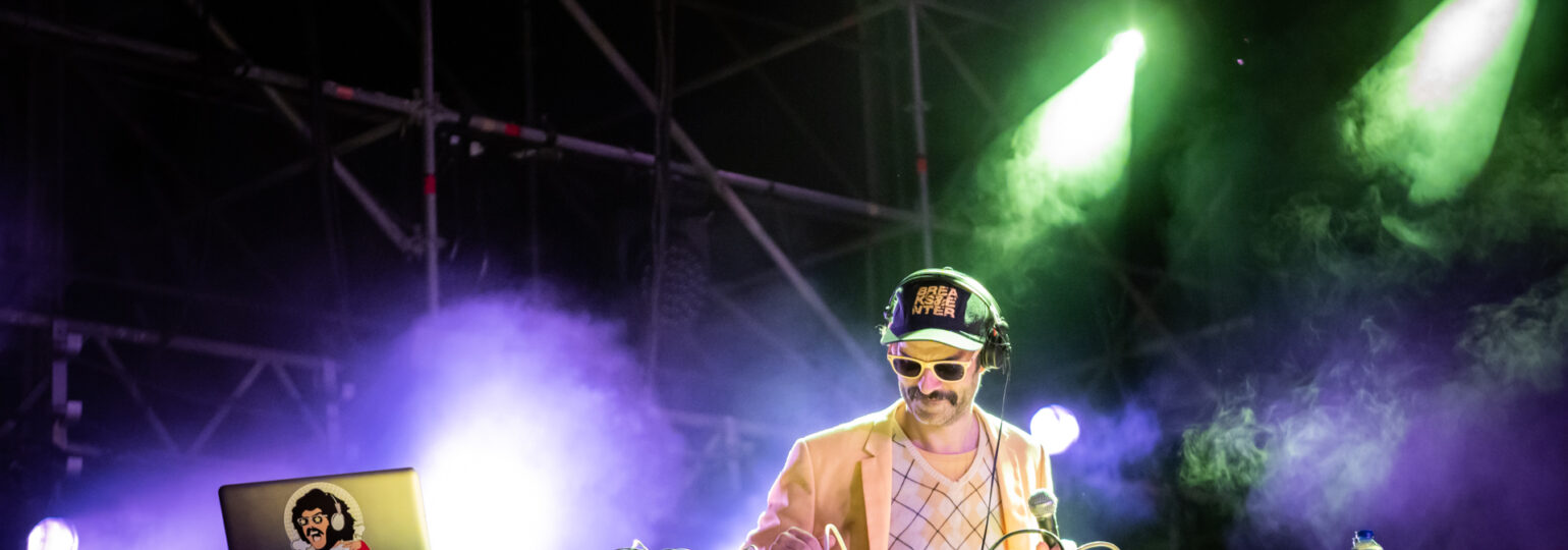Photographie dynamique du groupe Bootleggers Untied en pleine performance, capturant l’énergie brute et l’interaction avec le public lors de leur concert.