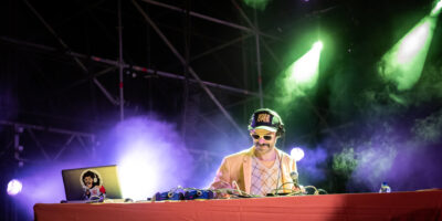 Photographie dynamique du groupe Bootleggers Untied en pleine performance, capturant l’énergie brute et l’interaction avec le public lors de leur concert.