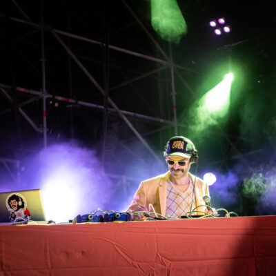 Photographie dynamique du groupe Bootleggers Untied en pleine performance, capturant l’énergie brute et l’interaction avec le public lors de leur concert.