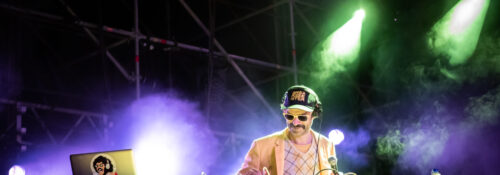 Photographie dynamique du groupe Bootleggers Untied en pleine performance, capturant l’énergie brute et l’interaction avec le public lors de leur concert.