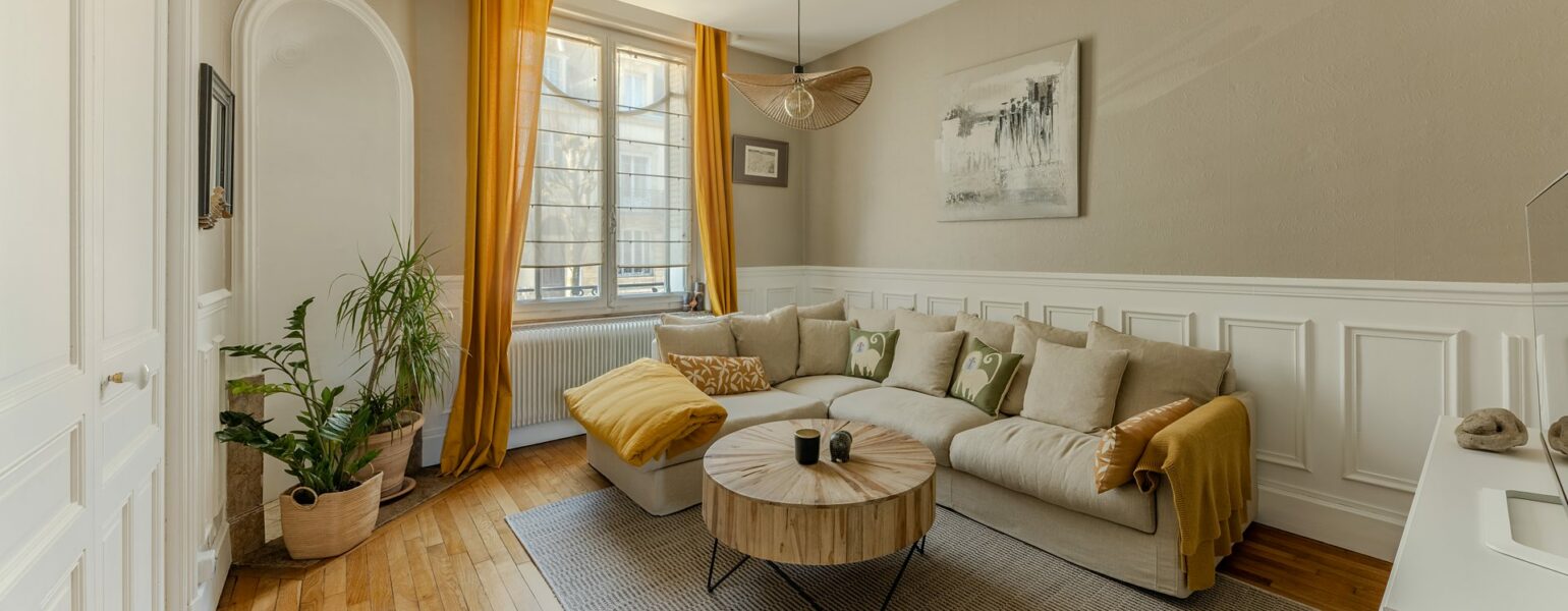 Séjour lumineux appartement Nancy Airbnb – canapé, table basse, lumière naturelle