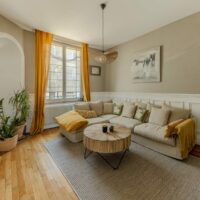 Séjour lumineux appartement Nancy Airbnb – canapé, table basse, lumière naturelle