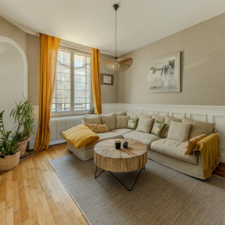 Séjour lumineux appartement Nancy Airbnb – canapé, table basse, lumière naturelle