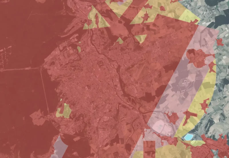 Vue satellite d'une ville avec superpositions de zones colorées.