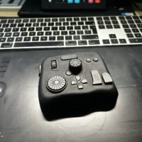 Contrôleur TourBox noir posé sur une tablette graphique Wacom.