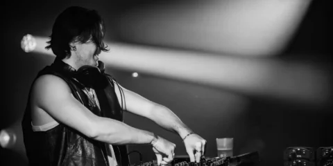 DJ mixant sur une platine Pioneer en noir et blanc.