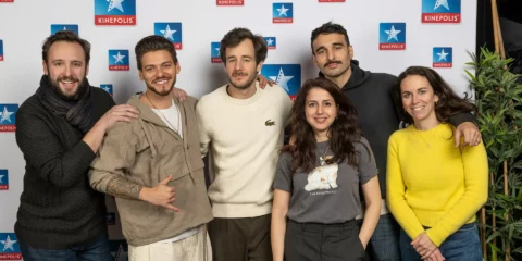 Groupe de six personnes posant devant un mur Kinepolis.