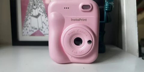 Appareil photo instantané rose InstaPrint sur une surface blanche.