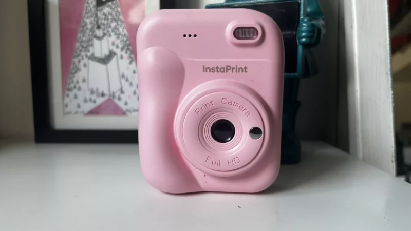 Appareil photo instantané rose InstaPrint sur une surface blanche.