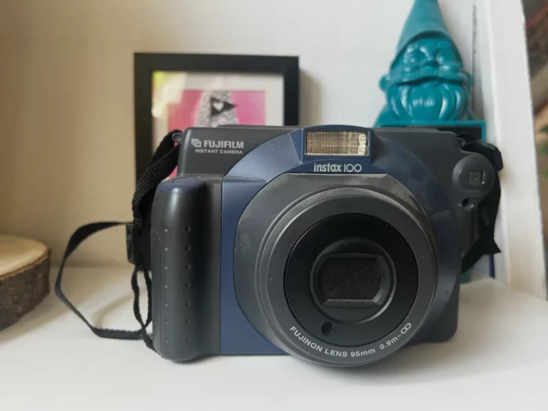 Appareil photo instantané Fujifilm Instax 100 sur une étagère.