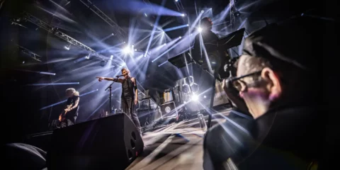 Groupe de musique sur scène sous des projecteurs éclatants.