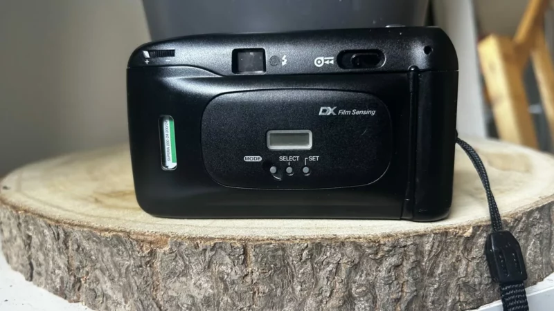 Arrière d'un appareil photo argentique compact noir sur bois.