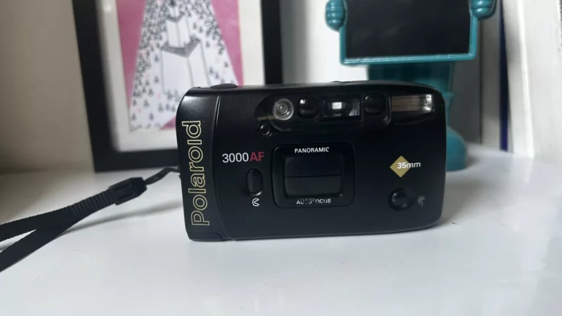 Appareil photo compact noir Polaroid 3000AF sur surface blanche.