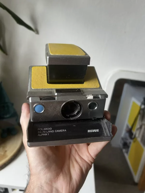 Appareil photo vintage Polaroid SX-70 avec panneaux jaunes.