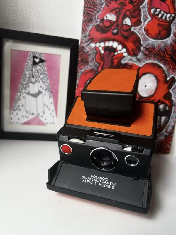 Appareil photo Polaroid SX-70 vintage noir et orange.