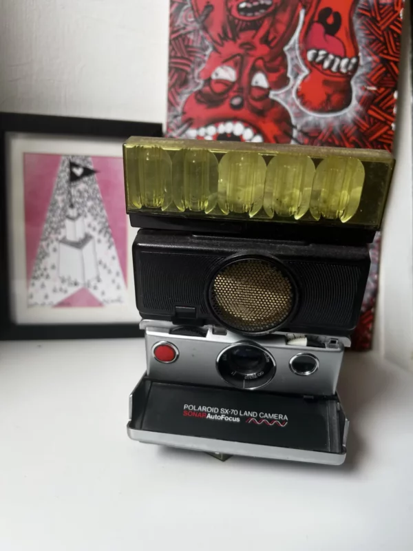 Appareil photo Polaroid SX-70 vintage avec flash jaune.