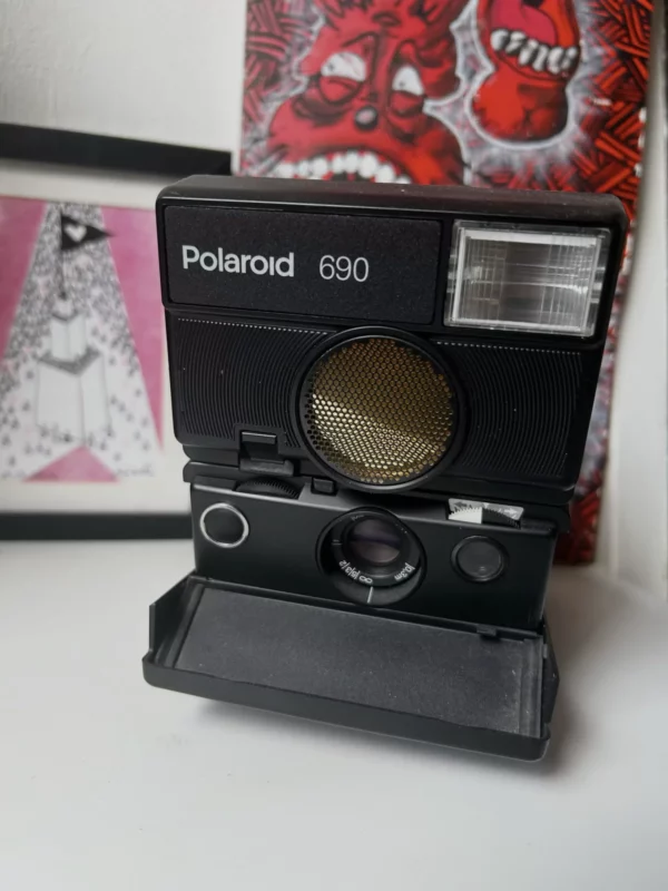 Appareil photo Polaroid 690 vintage sur un bureau blanc.