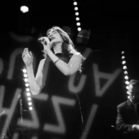 Chanteuse de jazz sur scène en noir et blanc.