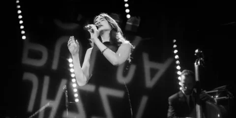 Chanteuse de jazz sur scène en noir et blanc.