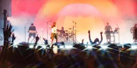 Concert en direct avec le chanteur Yamê, musiciens et public enthousiaste.