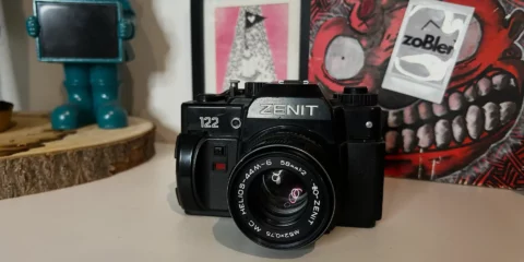 Appareil photo argentique Zenit 122 noir sur un bureau.