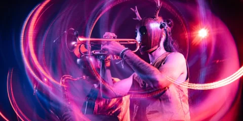 Musicien avec masque de cerf jouant de la trompette.