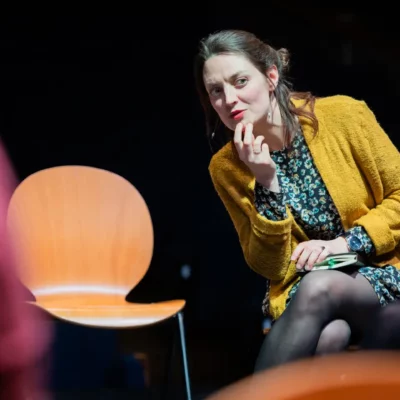 Femme pensive en gilet jaune assise à une conférence.