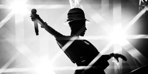 Silhouette d'une chanteuse avec micro sous les projecteurs.