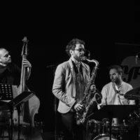 Quartet de jazz en concert sur une scène sombre.