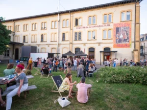 Foule rassemblée devant le Théâtre de la Manufacture en extérieur.
