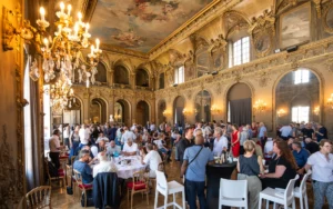Réception dans une salle de bal dorée ornée de fresques.