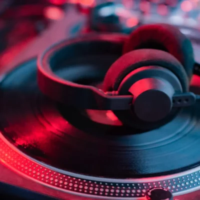 Casque de DJ sur platine vinyle avec néons colorés.