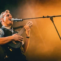 Musicien chantant et jouant du ukulélé sur scène.