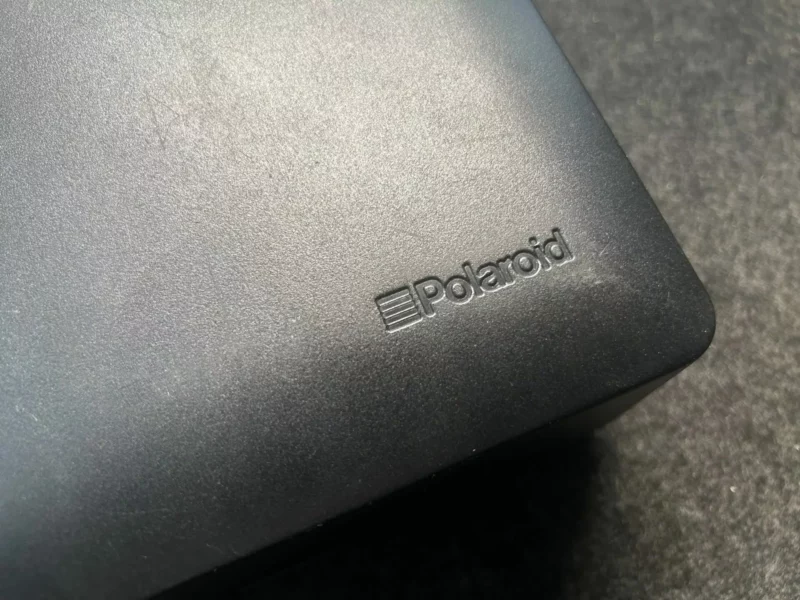 Logo Polaroid gravé sur une surface en plastique noir.