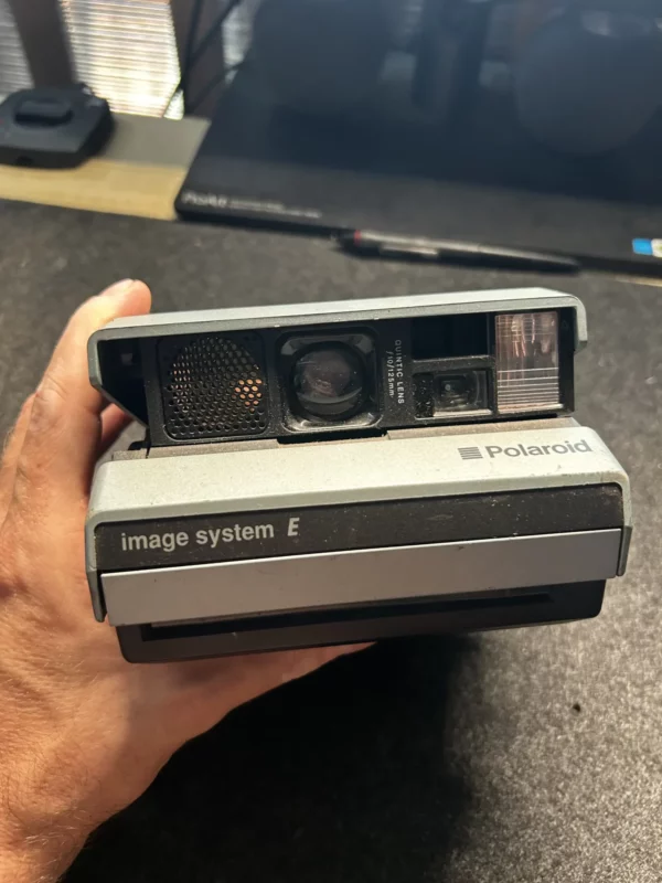 Appareil photo Polaroid Image System E tenu par une main.