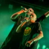 Deux chanteurs de rap sur scène sous lumière verte.