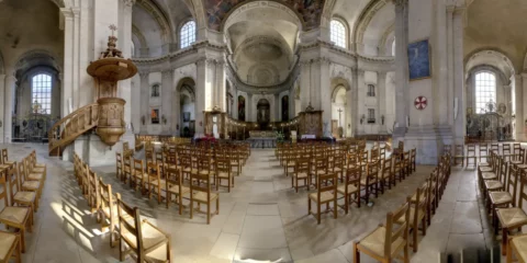 Intérieur d'une vaste église avec rangées de chaises.