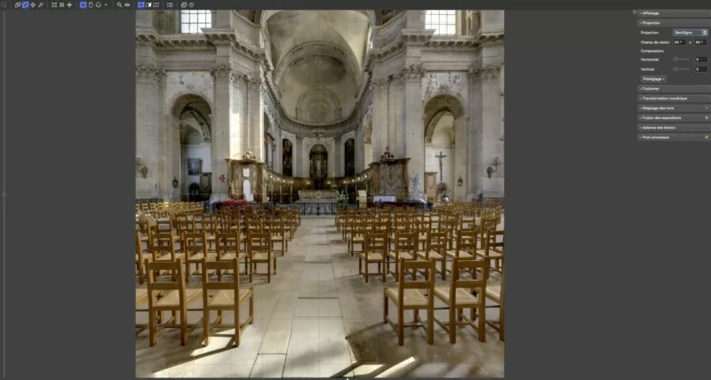 Intérieur d'une cathédrale avec des rangées de chaises en bois.